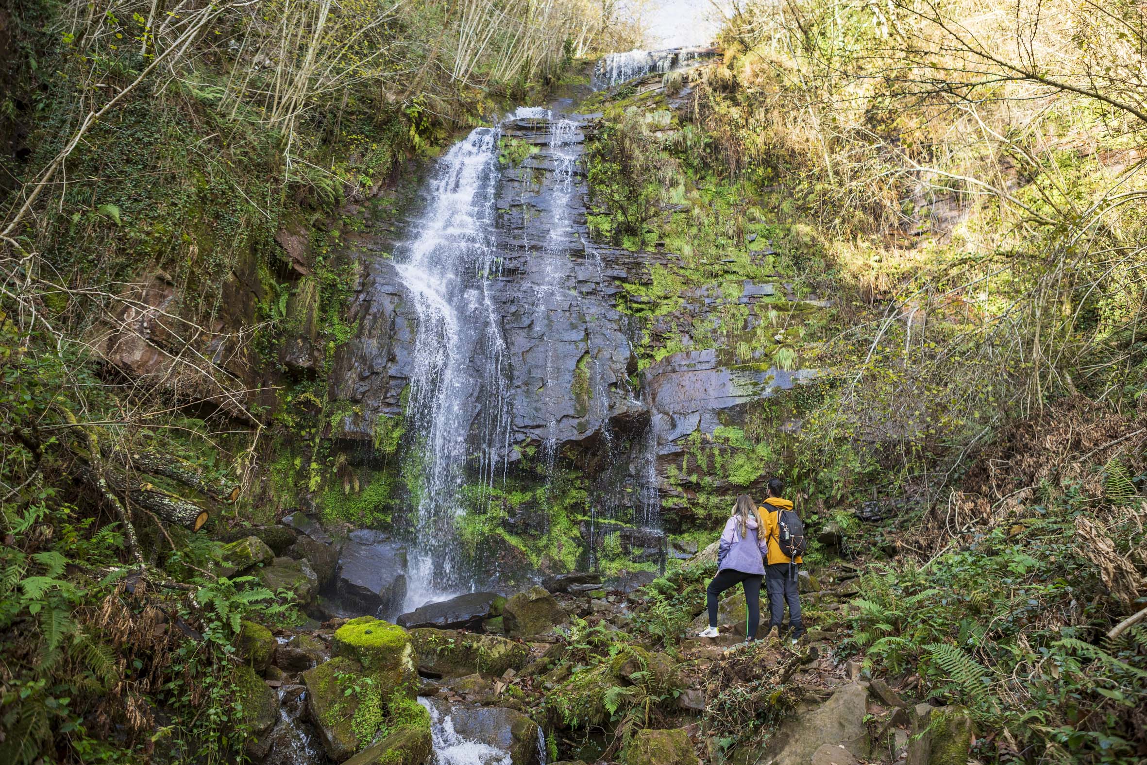 pareja de espaldas mirando la cascada de Oinaska